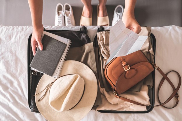 Girl traveler packing luggage in suitcase